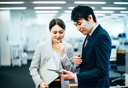ふたりの社員が電卓を見ながら話している写真